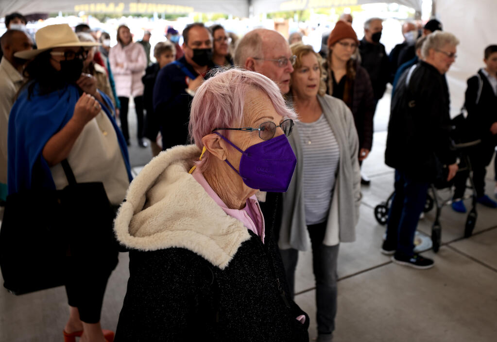 After arriving from Portland, Wednesday, April 20, 2022 Sunny Mawson waits for her luggage, while keeping her mask on at the Charles M. Schulz Sonoma County Airport, nearly 24 hours after the mask mandate was lifted on airlines and other forms of mass transit.  (Kent Porter / The Press Democrat) 2022