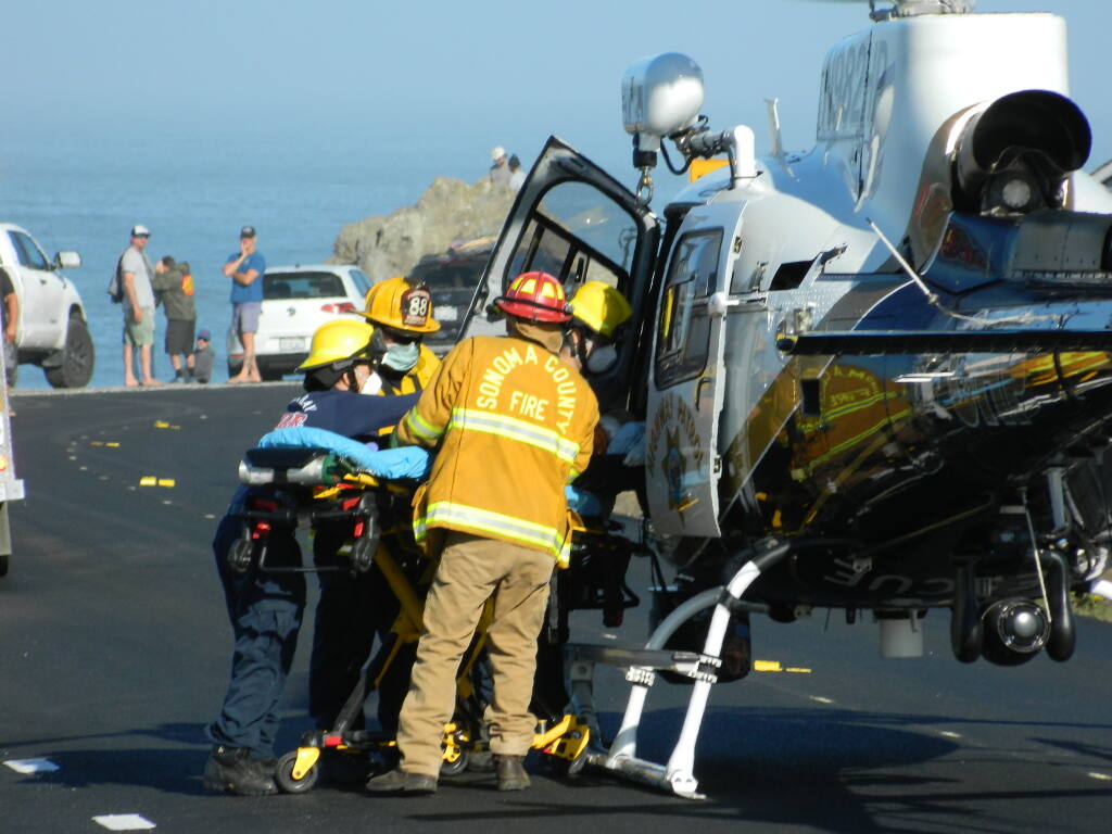 A man who was bitten by a shark while surfing off Salmon Creek Beach in Sonoma County, Calif. is loaded into a helicopter before he is airlifted to a hospital on Sunday, Oct. 3, 2021. (Pat Paterson)