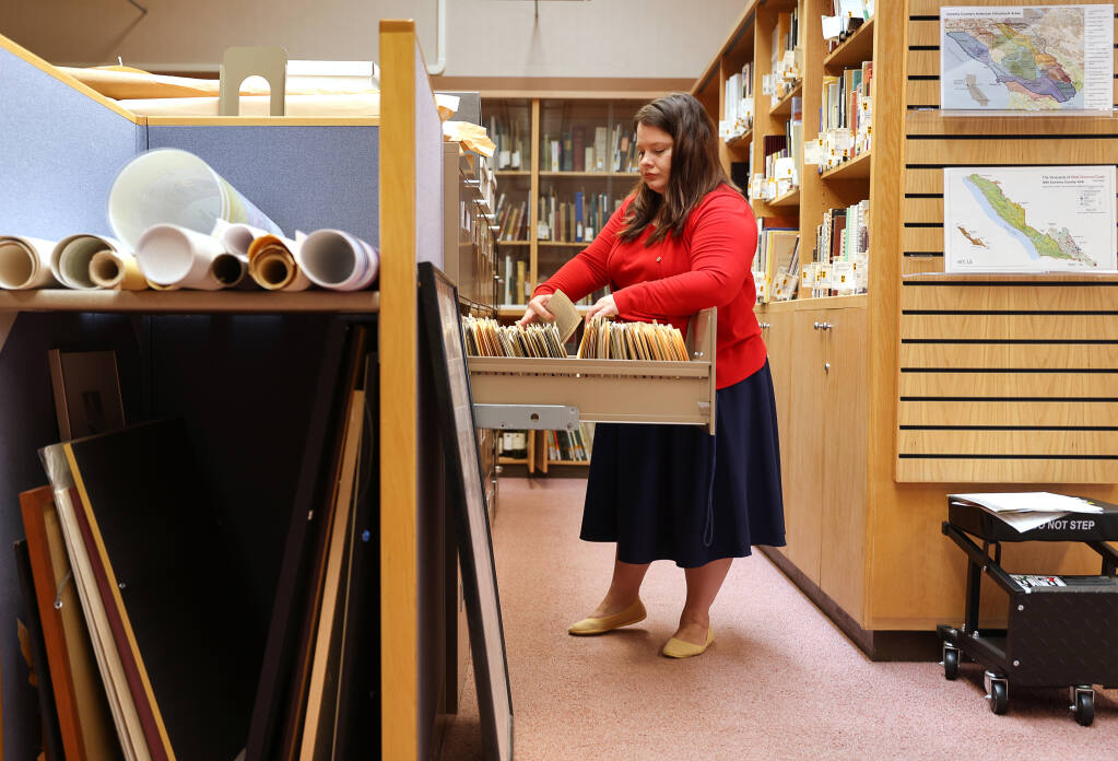 Wine librarian Megan Jones files items into folders at the Sonoma County Wine Library in Healdsburg on Friday, Sept. 23, 2022. (Christopher Chung / The Press Democrat)