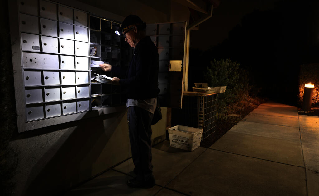 Bill Davis, a 29-year employee with the United States Postal Service, delivers mail Saturday evening, Oct. 15, 2022, at an apartment complex in Santa Rosa. (Kent Porter/The Press Democrat)