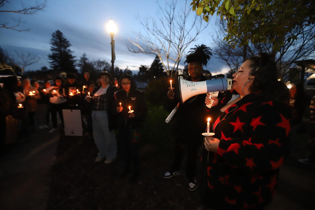 Brenda Arjona, of Santa Cruz, uses a bullhorn to talk to a crowd of people mourning victim Sylvia Bracamonte on the third anniversary of her fatal stabbing, during a candlelight vigil held near where she worked, on Old Redwood Highway, Monday, March 20, 2023, in Cotati. (Darryl Bush / For The Press Democrat)