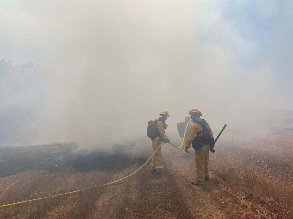Fire personnel are on the scene of a vegetation fire along Mark West Springs Road at Riebli Road on Wednesday, May 26, 2021. (Kent Porter / The Press Democrat)