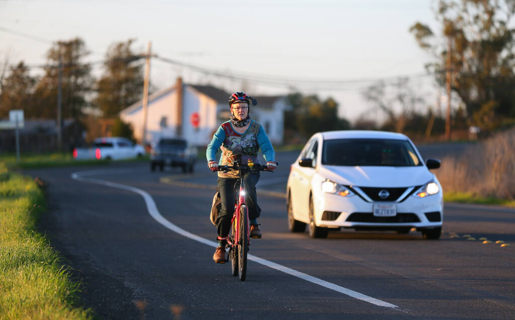 Eris Weaver, executive director of the Sonoma County Bicycle Coalition, commutes home on her e-bike after work, along Petaluma Hill Road, in Santa Rosa on Wednesday, Feb. 10, 2021. (Christopher Chung / The Press Democrat)