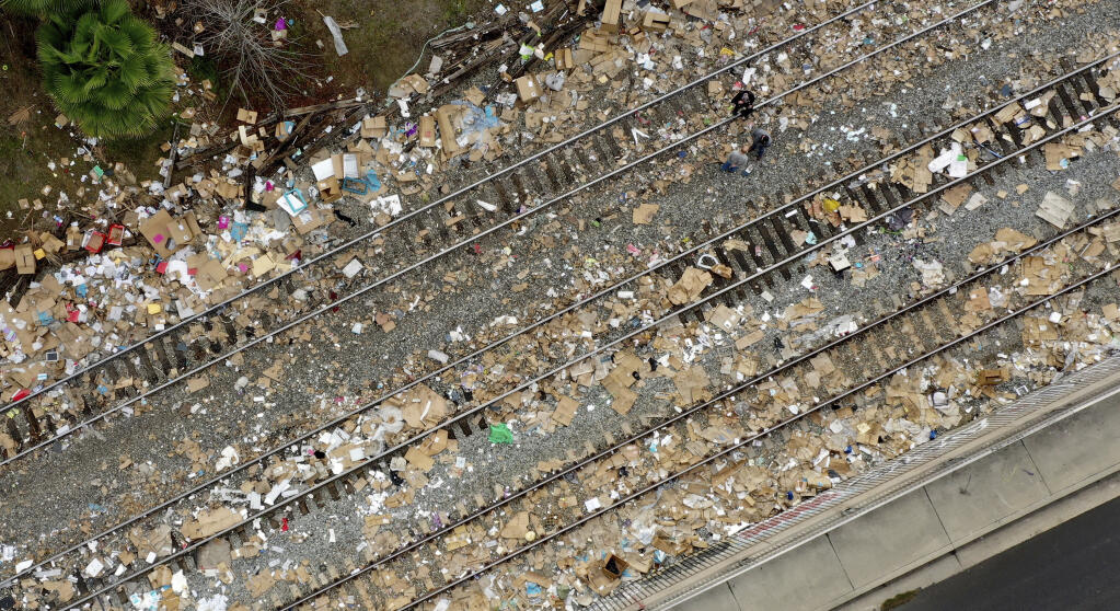 Shredded boxes and packages and debris are strewn along at a section of the Union Pacific train tracks in downtown Los Angeles on Tuesday, Jan. 18, 2022. (Dean Musgrove /The Orange County Register via AP)