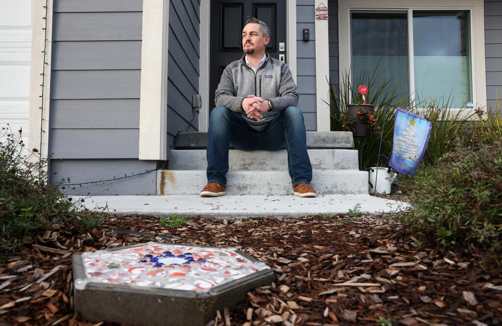 Jeff Okrepkie, who founded Coffey Strong after the 2017 Tubbs fire, empathizes with people having to deal with the aftermath of losing their homes to wildfires. In the foreground is a stepping stone his sister made with dishes recovered from their home destroyed in the Tubbs fire.  While he says he has become numbed to hearing about big fire after big fire, high winds and the smell of smoke get to him. (Christopher Chung/ The Press Democrat)