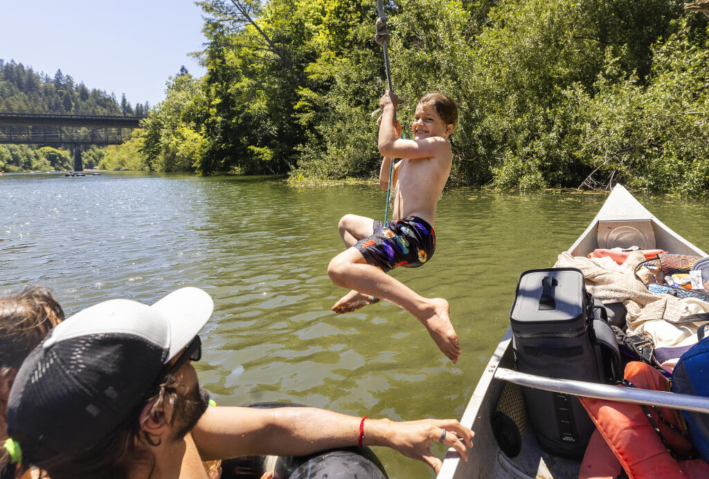 Leo Stefanotti, 7, of Oakland, jumps from a canoe on a rope swing on the Russian river in Guerneville on Friday, June 18, 2021.  (John Burgess/The Press Democrat)