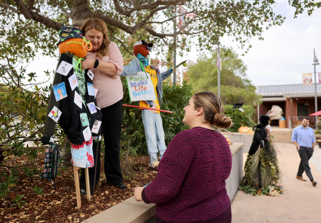 Yountville Parks and Recreation employees Samantha Holland, left, and Taylor Solis put up a scarecrow made by children at Camp Y-Ville’s Fun Day Club. Holland has led a two-year effort to create a master plan for the community’s parks system. Photo taken Monday, Oct. 16, 2023. (Beth Schlanker / The Press Democrat file)