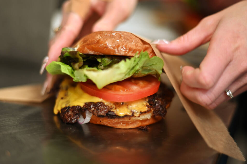 A smash burger with melted American cheese from chef Bob Simontacchi of Sonoma Burger, Monday, May 15, in the Gravenstein Grill kitchen in Sebastopol. (Erik Castro / For The Press Democrat)