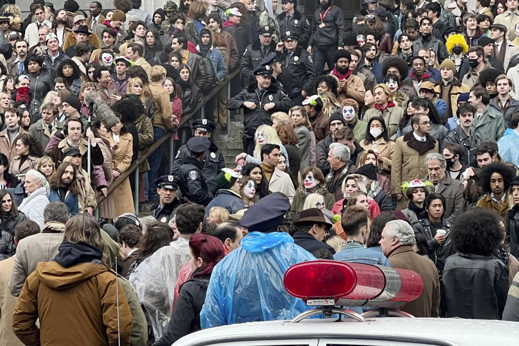 Throngs of actors portraying protesters, some in make-up, gather for the filming of a scene in the "Joker" movie sequel in New York, Saturday, March 25, 2023. Production crews had to wrestle with the possibility that filming could be disrupted by real-life protests over the Trump case, none of which have materialized so far. (AP Photo/Bobby Caina Calvan)