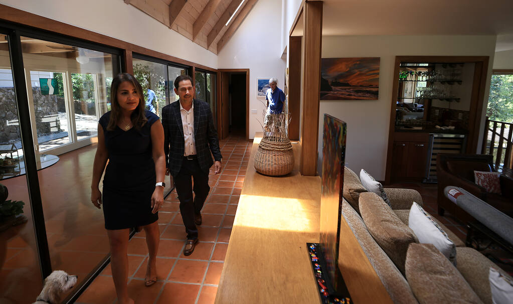 The Rendino's, Erika and David, complete a walk through in the home of Tony Apolloni, background, Tuesday, June 21, 2022 as the real estate agents prepare to list the home for sale near Oakmont. (Kent Porter / The Press Democrat) 2022