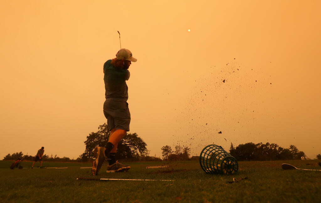 Ryan Zimmer hits balls under the smoke filled sky at the Windsor Golf Club driving range in Windsor on Tuesday, Sept. 8, 2020.  (Christopher Chung/ The Press Democrat)