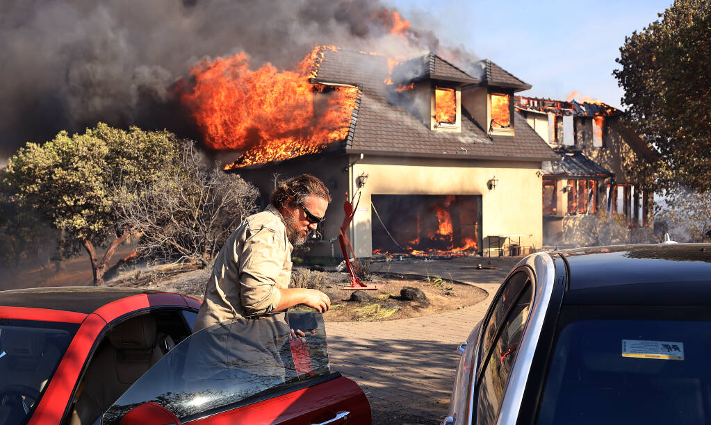 Joe Kikuchi  of Pacific Gas and Electric moves cars to safety as a house in Marina Estates above Lake Mendocino on the Hopkins fire burns, Sunday, Sept. 12, 2021 near Calpella.  (Kent Porter / The Press Democrat) 2021