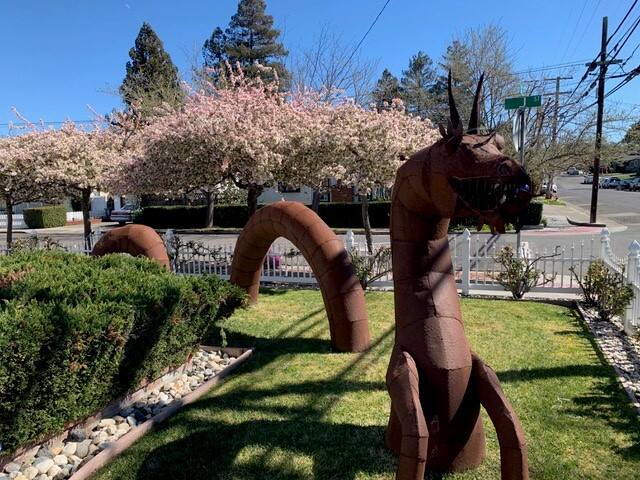 “We’ve lost count of how many people pass by on foot or pull over in their cars to take a picture or just tell us how our dragon makes them smile, which makes us smile,” said Kathleen Salvia, describing the neighborhood’s embrace of “Rusty” the dragon.(Courtesy of Henry and Kathleen Salvia)