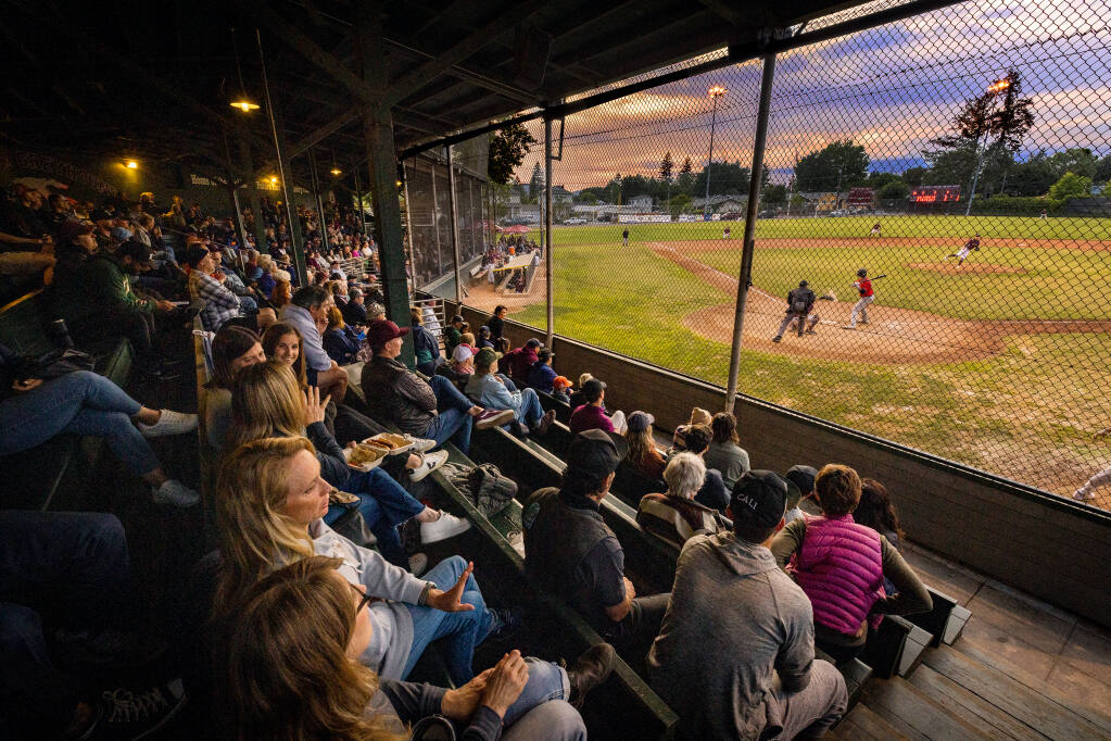 Fans feel the tradition of the game sitting on old wooden benches at the Healdsburg Prune Packers season opener against Gameday Prep Tuesday night, June 6, 2023. (John Burgess/The Press Democrat)