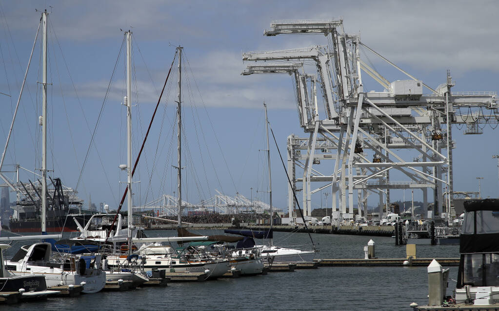 FILE - In this Friday, May 17, 2019, file photo, shipping cranes and a marina are near the Howard terminal area of the Port of Oakland in Oakland, Calif. The Oakland City Council approved preliminary terms for a new $12 billion waterfront ballpark project for the Athletics, Tuesday, July 20, 2021. But it's not clear if the 6-1 vote will be enough to keep the A's at the negotiating table instead of leaving the city. (AP Photo/Ben Margot, File)
