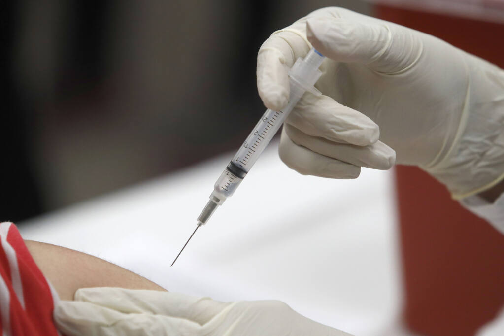 FILE — A patient receives an influenza vaccine as medical experts predict a rise in respiratory illnesses over the Thanksgiving holiday. (AP Photo/LM Otero, File)