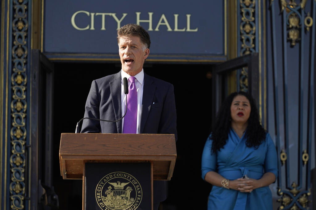 San Francisco health director Dr. Grant Colfax talks about the first confirmed case of the omicron variant as Mayor London Breed listens during a COVID-19 briefing outside City Hall in San Francisco, Wednesday, Dec. 1, 2021. The U.S. recorded its first confirmed case of the omicron variant Wednesday — a person in California who had been to South Africa. Genomic sequencing on the patient's virus was conducted at the University of California, San Francisco. (AP Photo/Eric Risberg)