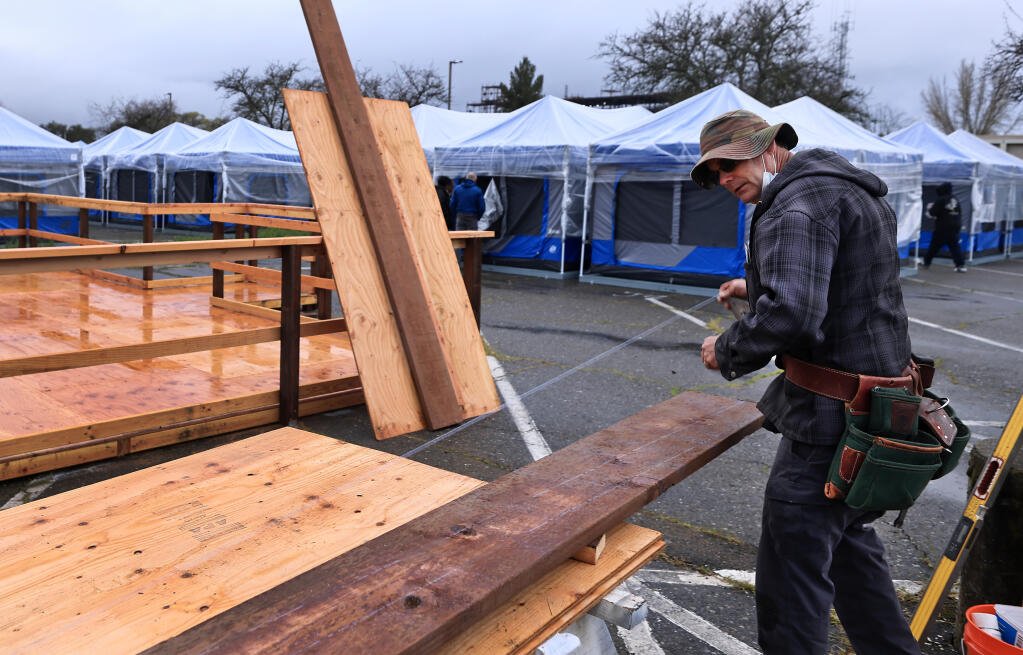 Tim Smith with the Sonoma County Probation Department, constructs an ADA ramp and platform for those living in a county sponsored homeless camp, Wednesday, March 29, 2023 in Santa Rosa. (Kent Porter / The Press Democrat) 2023
