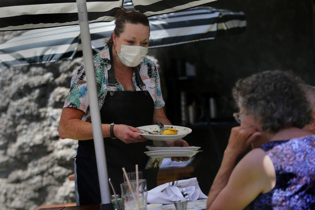 Waitress Shannon Dolan checks in on a table at Grossman's Noshery in Santa Rosa on Monday, Aug. 9, 2021. (Beth Schlanker/The Press Democrat)