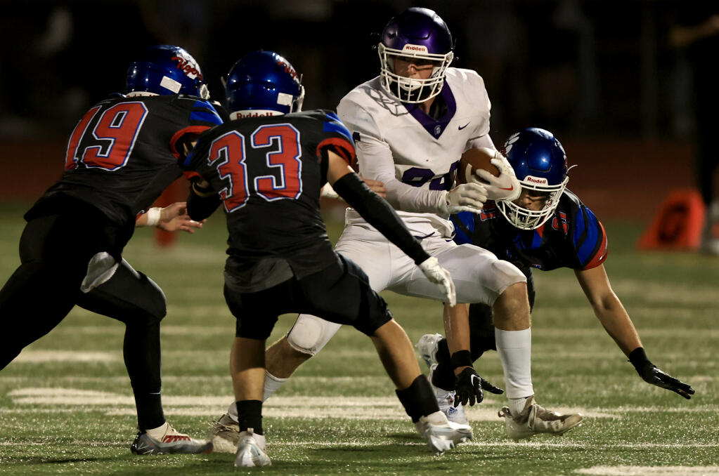 Petaluma ball carrier Silas Pologeorgis, is surrounded by Analy defenders, from left, Lincoln Johnson, Gitano Depaola And Liam Drake, Friday, Sept. 9, 2022 at Analy High School in Sebastopol. (Kent Porter / The Press Democrat)