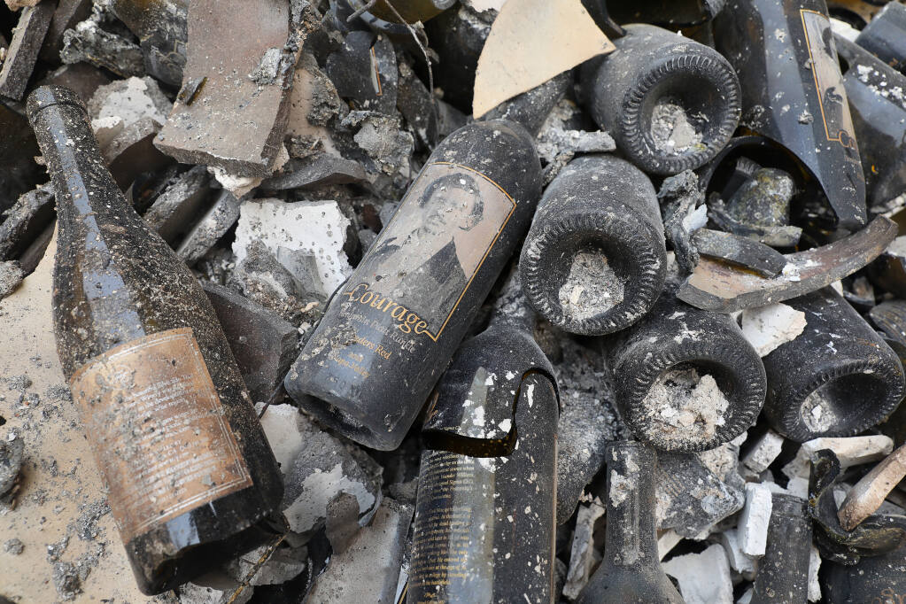 A bottle of Courage lays among the rubble of the Fairwinds Estate Winery, which was destroyed by the Glass  fire, in St. Helena on Tuesday, Sept. 29, 2020.  (Christopher Chung / The Press Democrat)