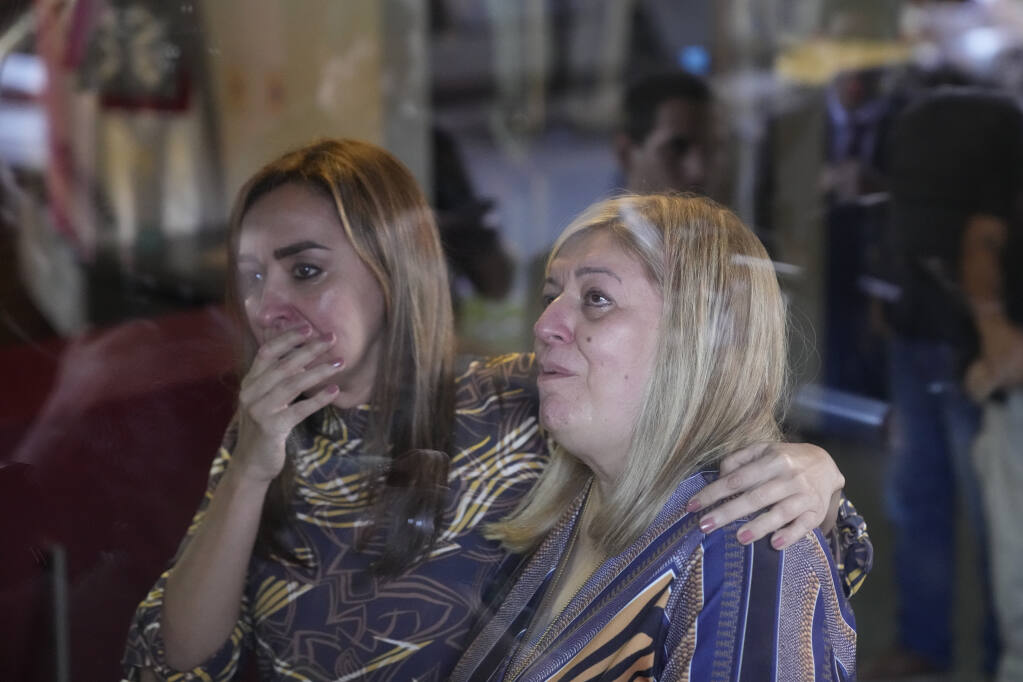 Attorney General of Paraguay Sandra Quiñonez, right, and another woman pray to a Virgin Mary statue at the entrance of her office after she found out about the killing during his honeymoon in Colombia of Paraguayan prosecutor Marcelo Pecci, in Asuncion, Paraguay, Tuesday, May 10, 2022. (AP Photo/Jorge Saenz)
