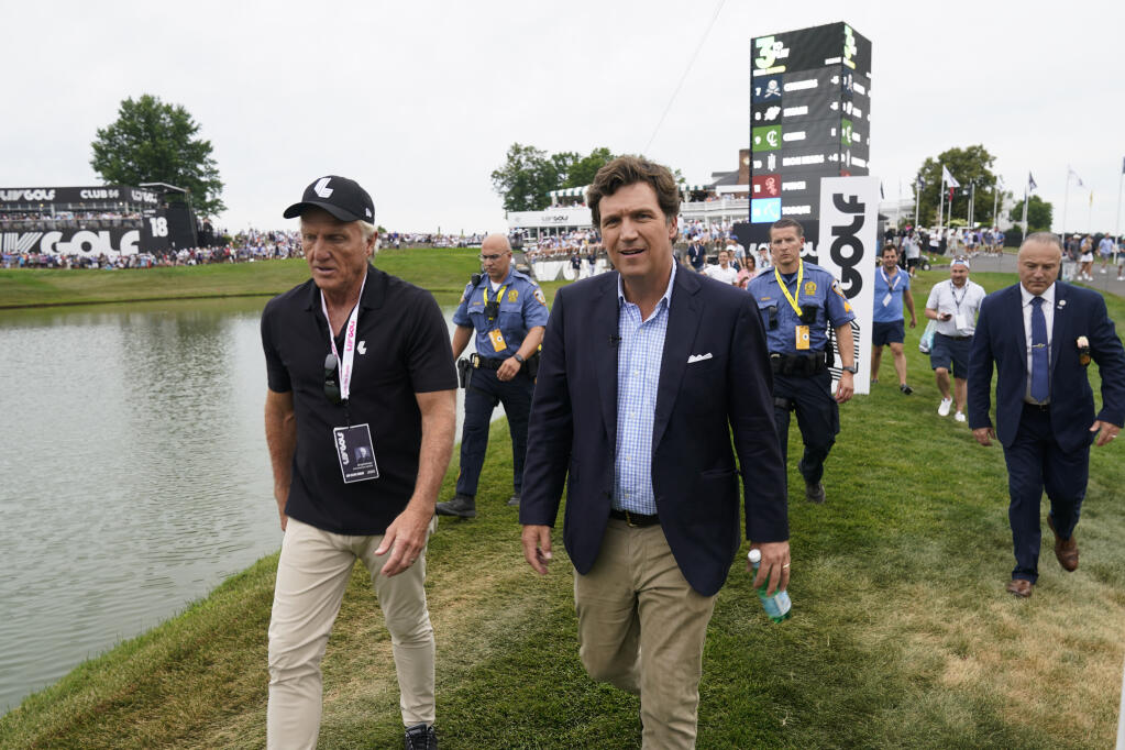 Tucker Carlson, front right, walks with LIV Golf CEO Greg Norman, left, during the final round of the Bedminster Invitational on Sunday, July 31, 2022, in New Jersey. (Seth Wenig / ASSOCIATED PRESS)