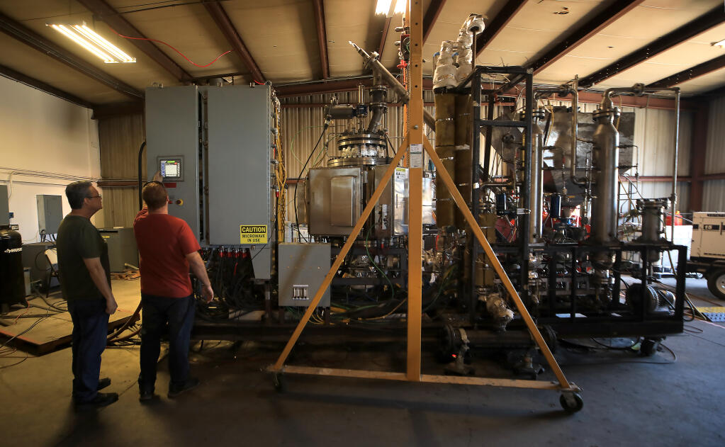 John Bergeron, director of operations, left, and electrical engineer Tyler Spott of Resynergi monitor the production of fuel from plastic recyclables, Friday, July 21, 2022, in Rohnert Park. (Kent Porter / The Press Democrat)
