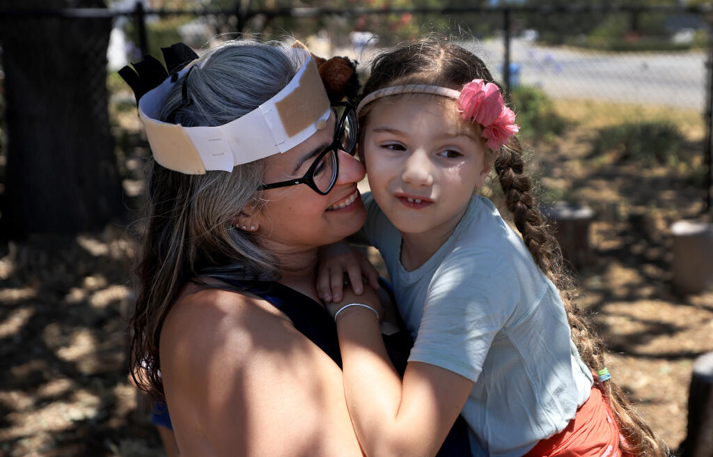 Victoria Webb and daughter Octavia, of Petaluma, share a quiet moment at the Veronda-Falletti Ranch in Cotati, Thursday, June 30, 2022 at the end of a week long camp that introduces children to farming and various farm animals.  (Kent Porter / The Press Democrat) 2022