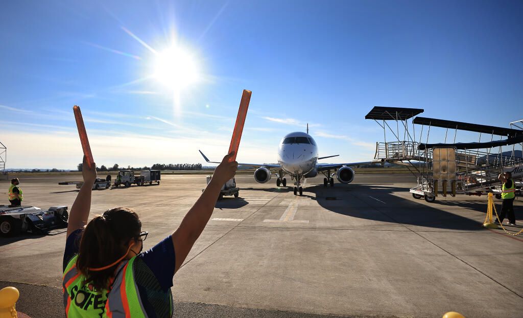 An Alaska Airlines flight is guided in to position at the Charles M. Schulz Sonoma County Airport, Tuesday, Nov. 23, 2021 in Santa Rosa.  (Kent Porter / The Press Democrat) 2021