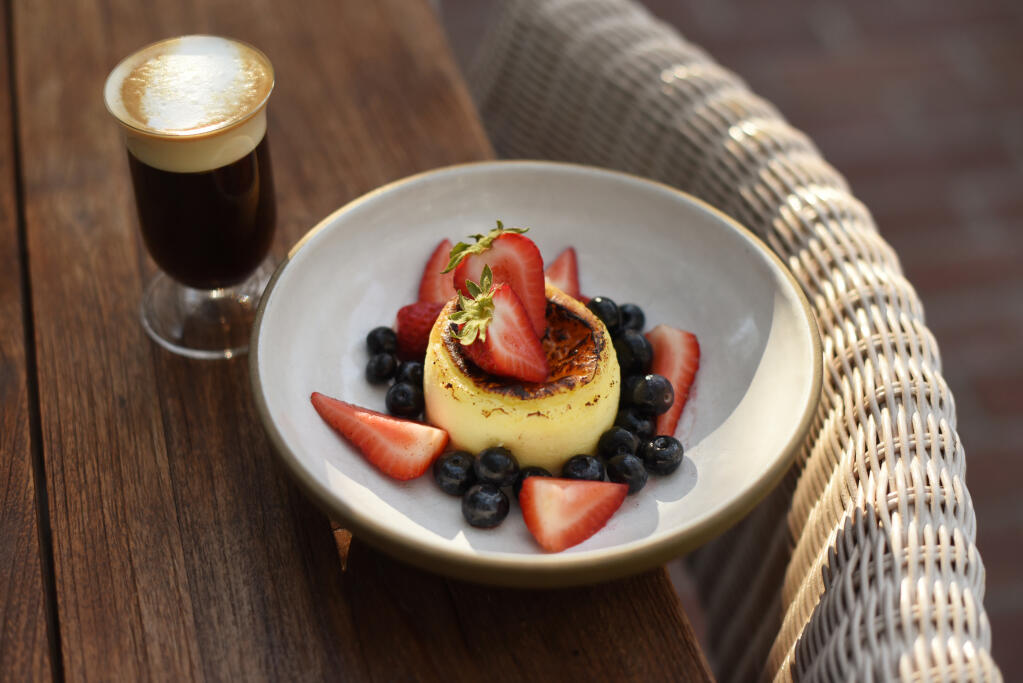 Basque cheesecake with vanilla macerated berries and shown with an Irish coffee at Layla restaurant at MacArthur Place Hotel and Spa in Sonoma, California on Thursday, May 6, 2021.(Erik Castro/for The Press Democrat)