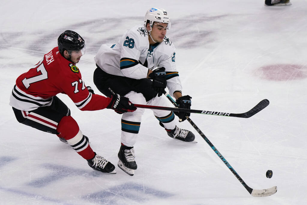 San Jose Sharks right wing Timo Meier, right, battles for the puck against Chicago Blackhawks center Kirby Dach during the first period of an NHL hockey game in Chicago, Sunday, Nov. 28, 2021. (AP Photo/Nam Y. Huh)