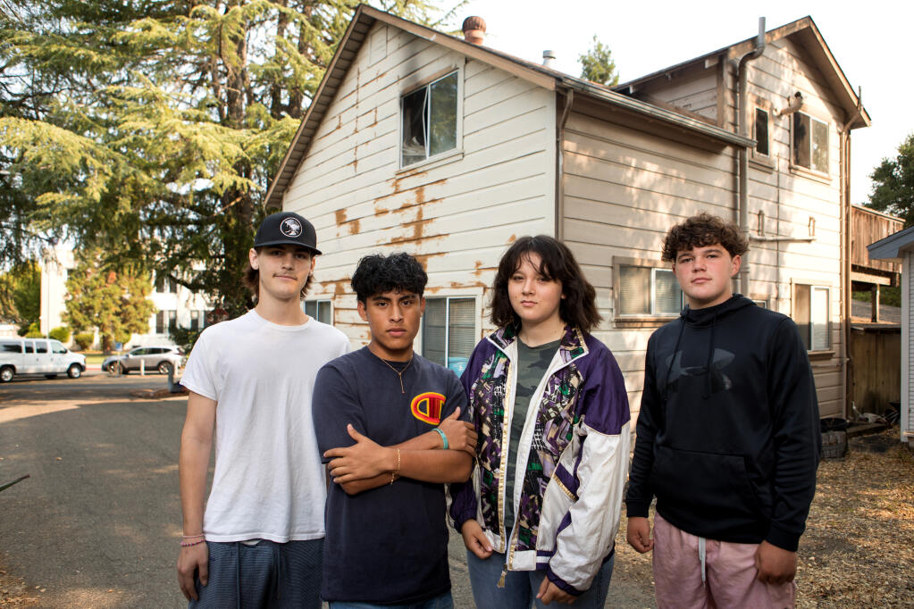Students from left, Luke Pierce, 17, senior, of Forestville; Osmarth Espejo Enriquez, 17, senior, of Santa Rosa; Emmeline Redding, 17, senior, of Santa Rosa; and Caden Lewis, 14, freshman, of Sebastopol, stand in front of a house near campus where they recently helped rescue a man from a house fire, near Analy High School, Friday, Sept. 9, 2022, in Sebastopol. (The upstairs window shows smoke damage from the fire.) (Darryl Bush / for The Press Democrat)