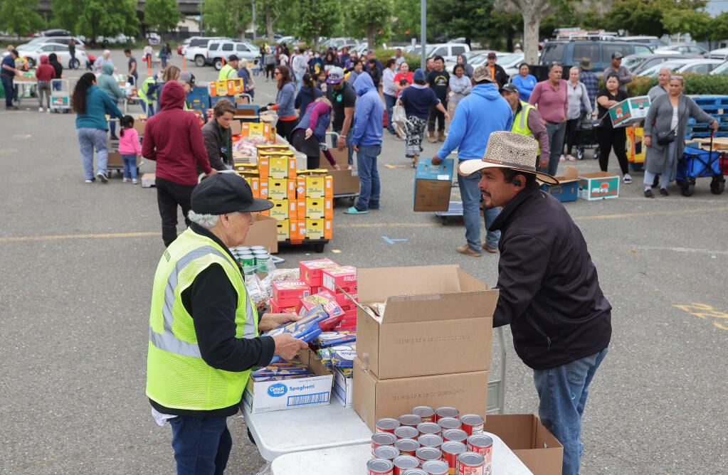 Redwood Empire Food Bank volunteers distribute food at the Santa Rosa Veterans Memorial Building. (CHRISTOPHER CHUNG / The Press Democrat)