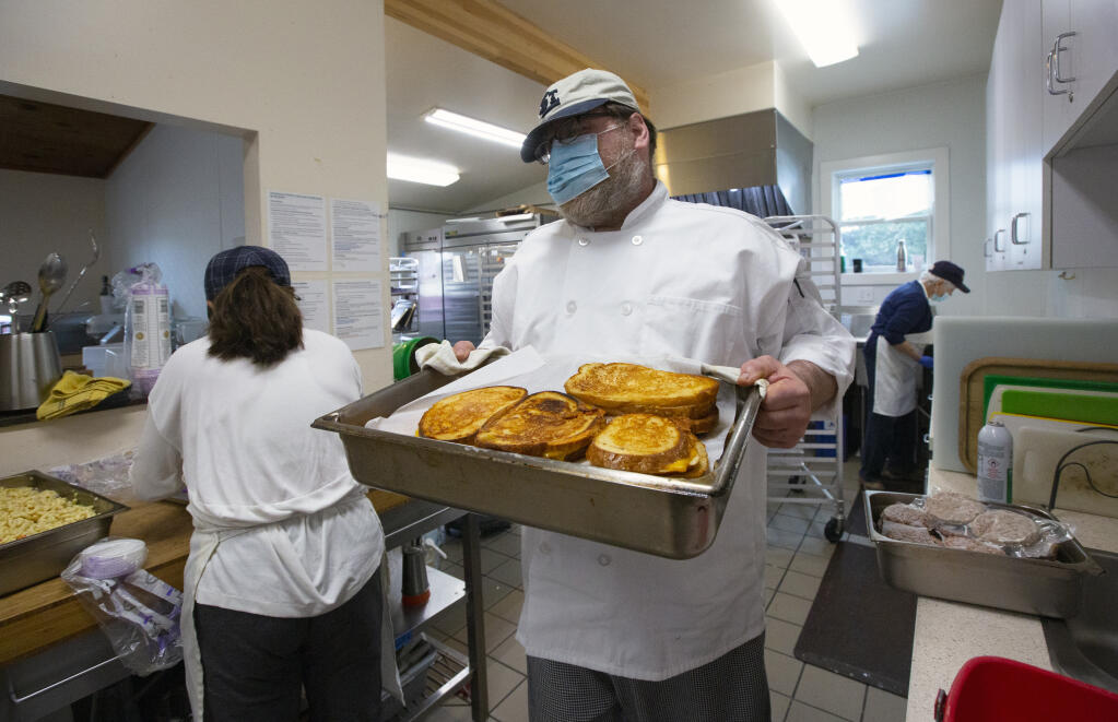 Executive chef Dan Kahn carries grilled cheese sandwiches, which will be packaged for delivery to those who rely on meals from Sonoma Overnight Support. (Photo by Robbi Pengelly/Index-Tribune)