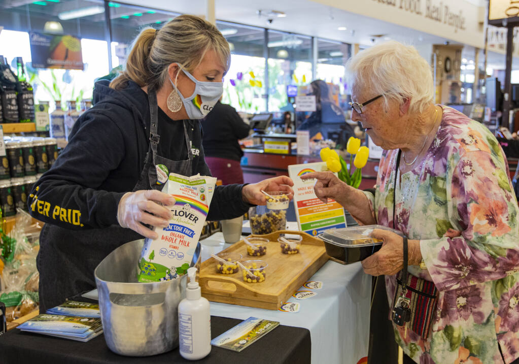 Food demonstrations are back, at the Stony Point Road. Oliver’s in Santa Rosa on Friday March 11, 2022.  Clover Stornetta brand ambassador Jennie Reimer serves Clover milk and cereal to Marion Oakley during an in store demo. (Chad Surmick / The Press Democrat)