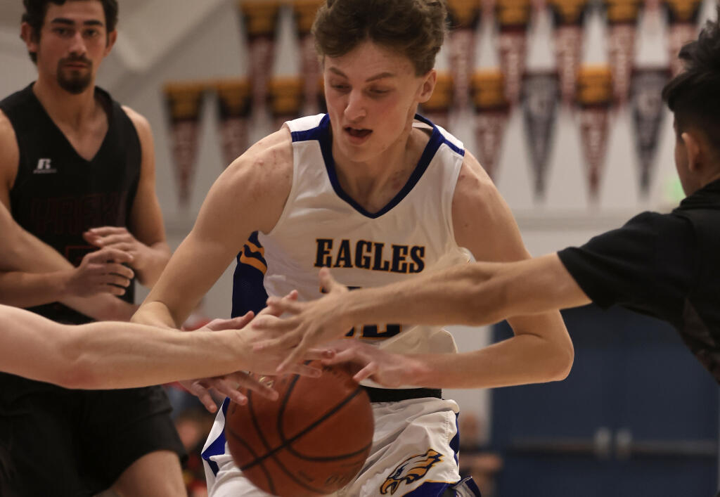 Cloverdale's Caden Axell, seen during basketball season, is surrounded by defenders’ arms against Yreka, during Cloverdale's 55-31 Div. 5 state playoff victory, Thursday, March 3, 2022. (Kent Porter / The Press Democrat)